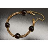 An early 20th century garnet set curb link bracelet,