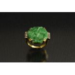 A carved jade and diamond ring, central octagonal jade panel carved with a flowers,