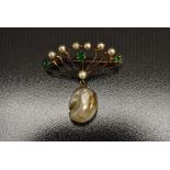 An early 20th Century Art Nouveau 9ct gold seed pearl and green garnet brooch, eight arm fan crest,