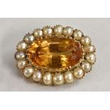 A Victorian citrine and seed pearl brooch, central large oval orangy yellow citrine,