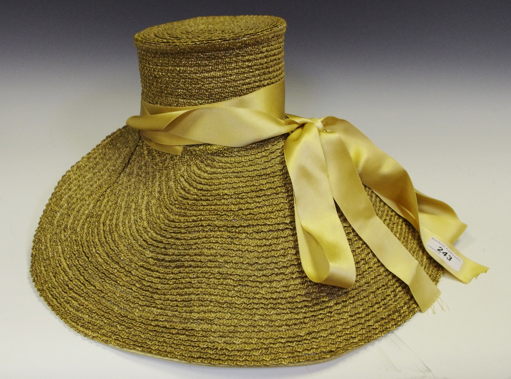 A lady's straw bonnet, tied with gold silk and gold ribbon tie.