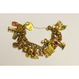 A rolled gold charm bracelet with various gold charms, 93g gross.