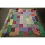 A mid 20th century knitted woollen patchwork double bed throw