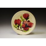 A Moorcroft Clematis pattern plate, tube lined with large flowerhead and foliage,