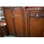 An early 20th century oak bedroom suite comprising two wardrobes,