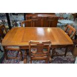 A 20th century oak drawer-leaf dining table; a set of four conforming dining chairs;