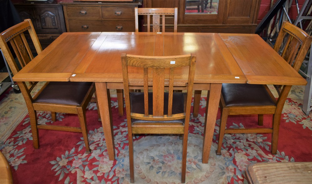 A 20th century light oak drawer-leaf dining table;