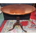 A George III mahogany occasional table, near-circular tilting top, turned column, triform base,