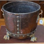 A copper log bucket, brass paw feet,