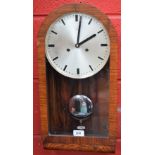 An Art Deco style walnut wall clock, arched case, silvered dial, baton indicators,