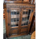 An oak leaded glazed linen-fold bookcase