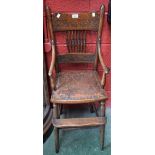 A 19th century oak child's high chair, shaped cresting rail carved with a fruiting branch,