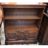 A 20th century oak bookcase, rectangular top above an adjustable shelf and a pair of panel doors,