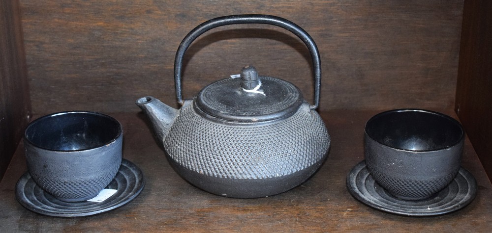 A Canadian iron tea kettle and two tea bowls and saucers,