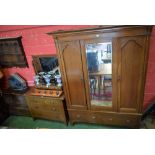 An early 20th century oak two piece bedroom suite comprising wardrobe and dressing table;