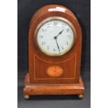 An Edwardian mahogany bullet shaped mantel clock, inlaid with an oval batwing patera,