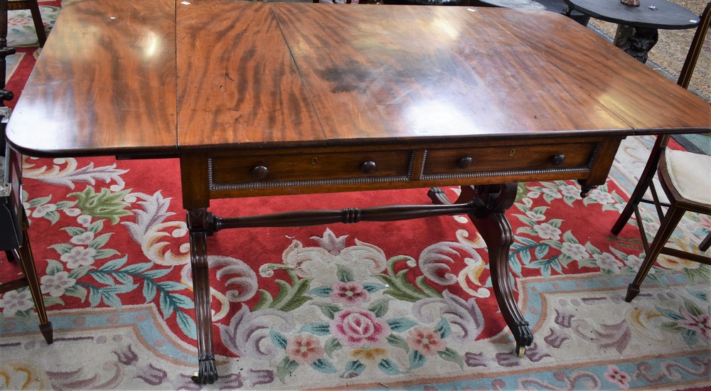 A Regency mahogany sofa table, rectangular top with fall leaves above a pair of frieze drawers,