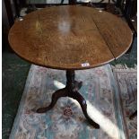 A 19th century oak near-circular occasional table, three piece tilting top, turned spreading column,