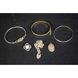 Jewellery - three silver bangles; a gilt bangle; a silver locket;