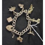A silver curb link charm bracelet, a variety of charms attached to include Spanish dancers,