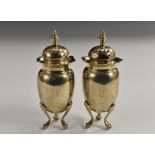 A pair of Victorian silver ovoid peppers, knop finials, domed pierced covers, wavy borders,