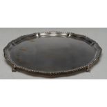 A silver shaped circular salver, gadrooned border, ball and claw feet, 36cm high, H.