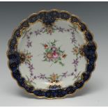 A Worcester shaped circular plate, painted with central flowers surrounded by puce floral festoons,