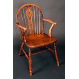 A 19th century elm Windsor elbow chair, hooped back with shaped and pierced splat, saddle seat,