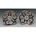 A pair of Worcester shaped circular plates, painted with alternating fan and vase shaped reserves,