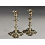 A pair of early George III silver cast table candlesticks, detachable nozzles, knopped stems,