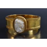 A carved shell cameo topped hinge bangle, central oval portrait of Flora within beaded frame,