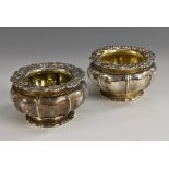 A pair of George IV silver melon shaped salts, anthemion, shell and leafy scroll borders,