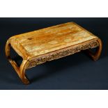 A Chinese hardwood low tea table, shaped frieze carved with scrolls and foliage centred by a seal,