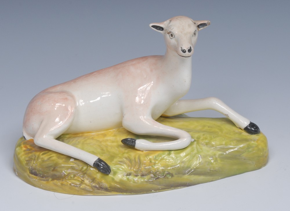 A Brameld model, of a deer, reclining, tan markings, shaped green oval base, 19cm wide, c.