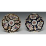 A pair of Worcester shaped circular plates, painted with alternating fan and vase shaped reserves,