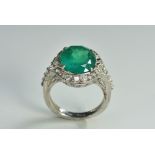 An emerald and diamond cluster ring, central oval emerald approx 6.