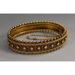 A Victorian Etruscan Revival hinged bangle,