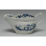 A Worcester Two Porter landscape sauceboat, decorated in underglaze blue within moulded cartouche,