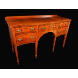 A 19th century mahogany serpentine sideboard, oversailing top above an arrangement of four drawers,