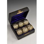 A set of six Edwardian silver napkin rings, embossed with Reynolds angels and leafy scrolls,