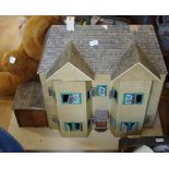 A mid 20th century dolls house in mid 20th century style, with garage, opening front.