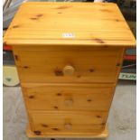 A small pine three drawer bedside cabinet, 65cm high,