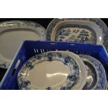 A large Willow pattern meat plate, transfer printed in blue and white; another, smaller; others,