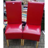 A pair of contemporary red upholstered high backed dining chairs.