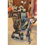 A golf trolley; another; two golf bags,
