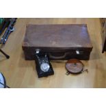 A vintage leather suitcase; a retro dial telephone;