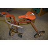 A child's Tri-ang tricycle, red livery, white spoke wheels, c.