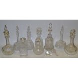 Nine various clear glass decanters and stoppers,