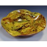 A Torquay Ware Art pottery wavy edge bowl, decorated in swirls of caramel,
