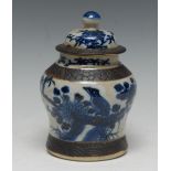 A Chinese baluster jar and cover, painted in tones of underglaze blue with a bird on a branch,